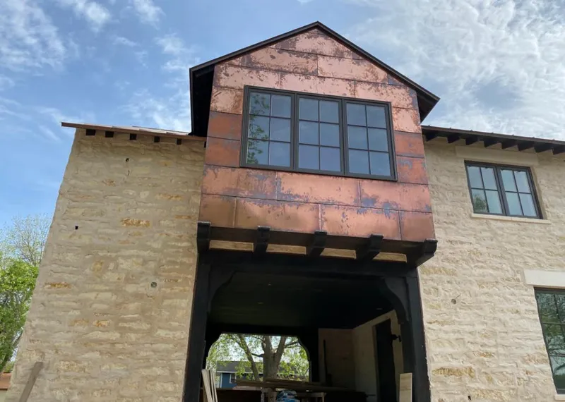 Copper metal panel facade on a stone building for Skylight Installation in Graham